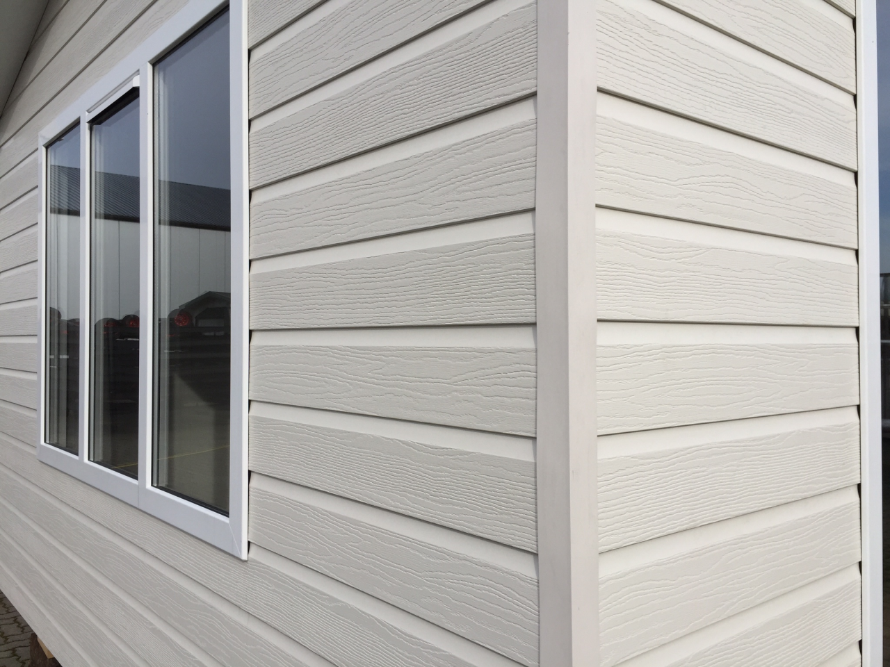 Een chalet bekleed met kunststof gevelbekleding van het merk Eurotexx in de kleur creme, RAL 9001
