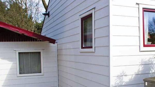 Kunststof schroten voor buiten biedt vele voordelen voor het bekleden van een chalet, woonboot of gevel Deze afbeelding bevat een foto van kunststof schroten voor buiten aan een chalet