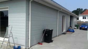 Gevel van een woning met kunststof gevelbekleding zie je op deze afbeelding. Met een verschillende houtsctructuren. Woning gevel met kunststof gevelbekleding met houtstructuur bekleden